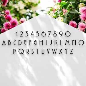 May include: A white background with black text showing the alphabet and numbers in a modern font. The letters are uppercase and the numbers are in a single row.