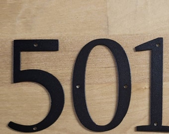 May include: Black metal house numbers 501. The numbers are cut out and have a flat, matte finish.