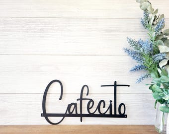 May include: Black metal wall decor with the word "Cafecito" in a cursive script font.