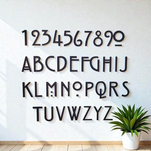 May include: Black, stylized numbers and alphabet letters are mounted on a white wall. The numbers 1 through 9 are displayed above the alphabet letters A through Z. A potted green plant sits in the lower right corner.