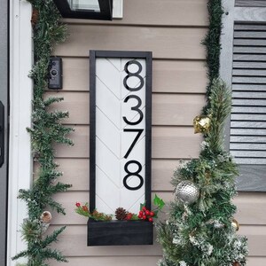 May include: Black and white wooden sign with a chevron pattern and the house number 8378 in black.