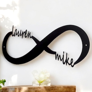 May include: Black metal infinity symbol wall decor with the names "Lauren" and "Mike" written in a cursive font.
