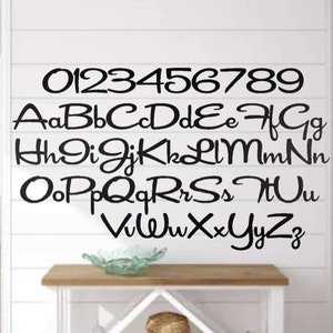 May include: Black and white alphabet and number wall decal with a cursive font. The letters and numbers are arranged in three rows. The numbers are in the top row, the lowercase letters are in the middle row, and the uppercase letters are in the bottom row.