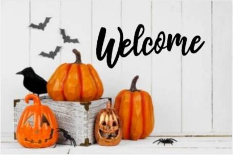 May include: A white wooden sign with the word "Welcome" in black script. The sign is decorated with orange pumpkins and black bats.