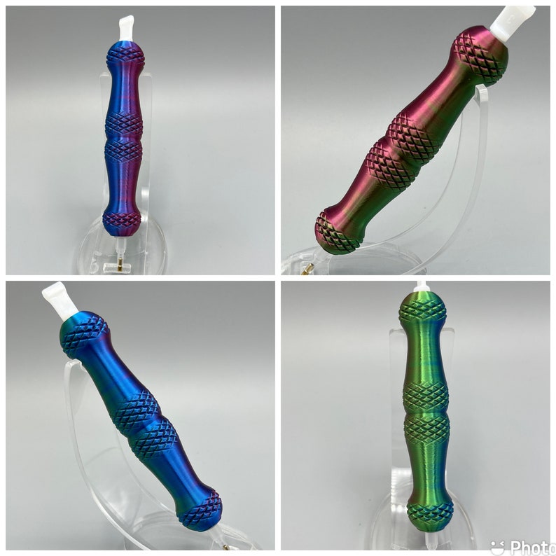 May include: Four iridescent metal tools with a pointed tip and a textured, diamond-shaped pattern. The tools are displayed on clear plastic stands.