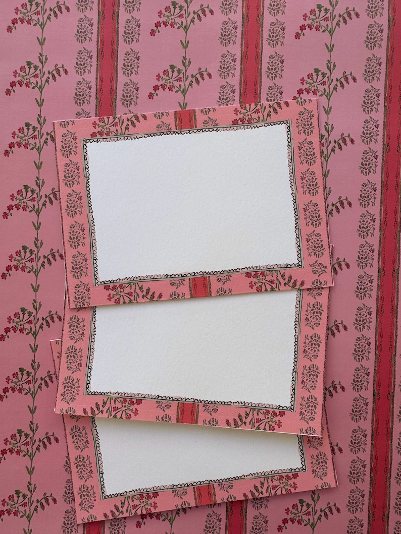 May include: Three rectangular cards with a pink floral border featuring green stems and red blossoms. Each card has a central white rectangular space framed by a hand-drawn black scalloped line, layered over a matching pink floral patterned background.