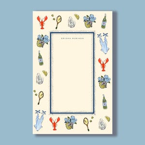 May include: Cream-colored stationery with a navy blue border and decorative illustrations. The border features a lobster, oysters, lemons, flowers, and bottles. The text "ERISHA RUBINOH" is printed in the center.
