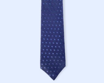 Puede incluir: Una corbata azul oscuro con un patrón de lunares blancos.