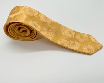 May include: A yellow silk tie with a white floral pattern.