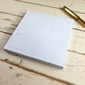 Peut inclure: Un bloc-notes de planification hebdomadaire blanc avec une icône de soleil dans le coin supérieur gauche. Le bloc-notes est divisé en sept sections, étiquetées avec les jours de la semaine : MO, TU, WE, TH, FR, SA, SU.