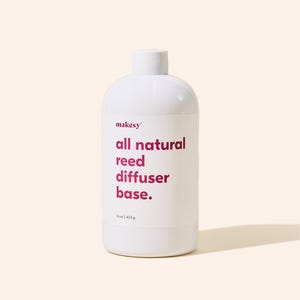 May include: A white cylindrical bottle with a rounded top, labeled "makesy" and "all natural reed diffuser base." The text is in a deep pink color. The bottle contains 16 oz / 453 g of product.