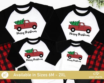 May include: Red and black Christmas pajamas with a white truck carrying a Christmas tree and the text "Merry Christmas".