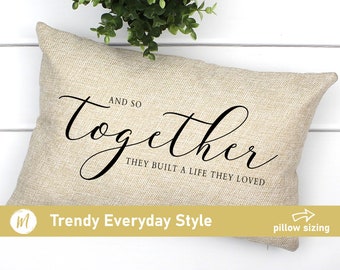 May include: A beige throw pillow with the text "And so together they built a life they loved" in black cursive font.
