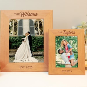 May include: Two wooden picture frames with photos of couples. The larger frame says "The Wilsons" and "EST. 2025". The smaller frame says "The Taylors" and "EST. 2025".