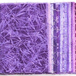 Könnte beinhalten: Ein Bündel violetter Stoffquadrate mit verschiedenen Mustern, darunter ein einfarbiges violettes Quadrat mit einer dezenten Textur und ein gestreiftes Quadrat mit einem Blumenmuster.