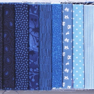 Könnte beinhalten: Eine Sammlung von zehn Stoffstreifen in verschiedenen Blautönen, von Dunkelblau bis Hellblau. Die Stoffe haben unterschiedliche Muster, darunter Paisley, Punkte, Blumen, Streifen und einfarbige Stoffe.