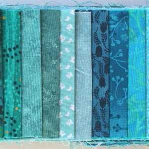 Könnte beinhalten: Eine Sammlung von 14 Stoffstreifen in verschiedenen Blautönen und Grüntönen mit unterschiedlichen Mustern, darunter florale, geometrische und abstrakte Designs.