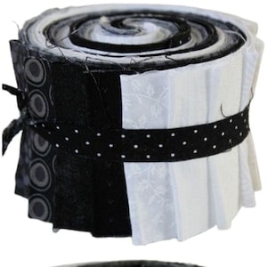 Könnte beinhalten: Eine Rolle mit schwarzen und weißen Stoffresten, gebunden mit einem schwarzen Band mit weißen Punkten. Die Stoffreste sind spiralförmig angeordnet.