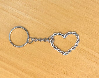 May include: A silver keychain with a braided heart charm and a silver key ring.