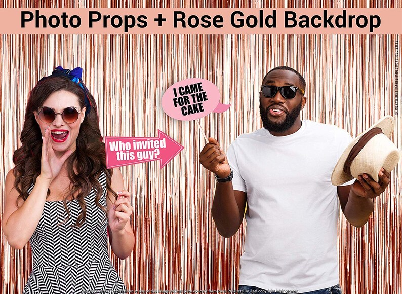 Op de afbeelding: Twee mensen houden fotobooth-rekwisieten vast voor een roze gouden tinsel achtergrond. De rekwisieten zeggen "Wie heeft deze man uitgenodigd?" en "Ik kwam voor de taart".