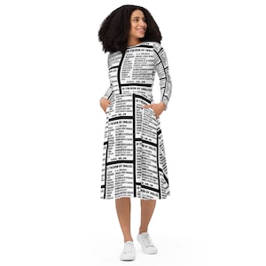 Puede incluir: Un vestido blanco y negro con manga larga y capucha. El vestido tiene un estampado de un artículo de periódico con el título "12 tribus de Israel" y una lista de diferentes grupos étnicos.