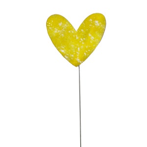 May include: A yellow heart-shaped garden stake with a distressed finish. The heart is mounted on a thin, silver-coloured metal rod. The stake is designed for outdoor use and adds a decorative touch to gardens and flower beds.