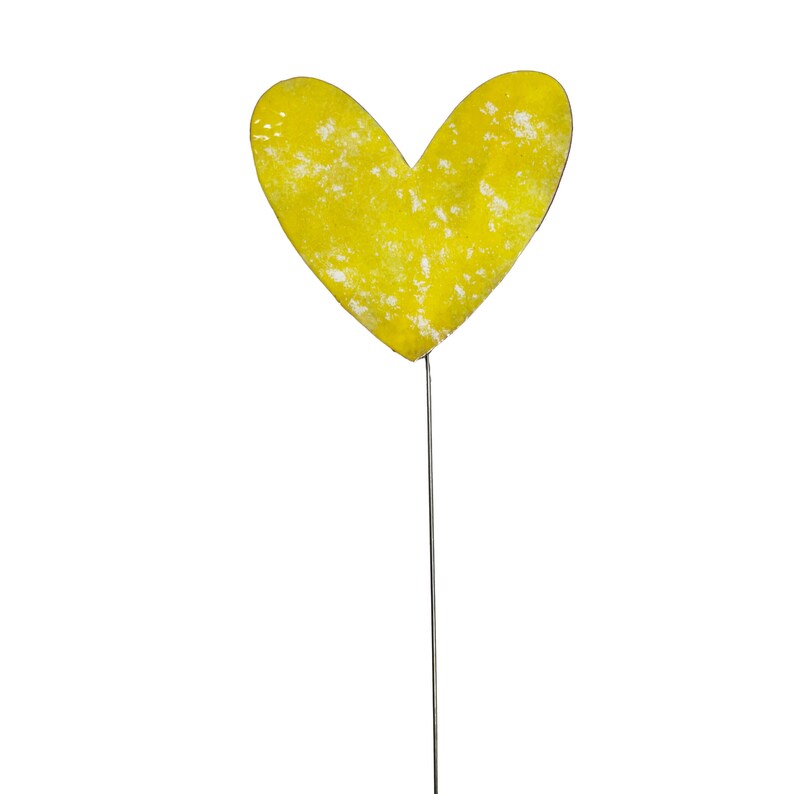 May include: A yellow heart-shaped garden stake with a distressed finish. The heart is mounted on a thin, silver-coloured metal rod. The stake is designed for outdoor use and adds a decorative touch to gardens and flower beds.