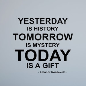 Puede incluir: Una pared blanca con texto negro que dice "Ayer es historia, Mañana es misterio, Hoy es un regalo - Eleanor Roosevelt -"