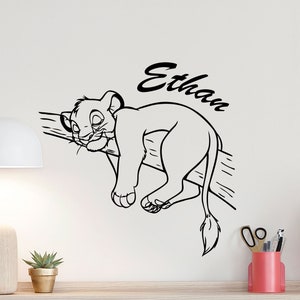 Peut inclure: Illustration en noir et blanc d'un lionceau dormant sur une branche avec le nom Ethan écrit au-dessus.