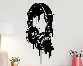May include: Black and white silhouette of headphones with paint splatters. The headphones are on a white wall.