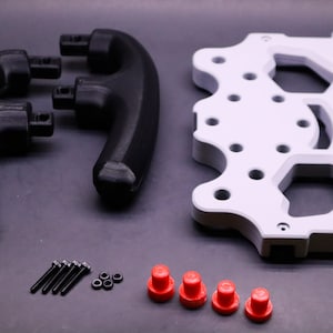 May include: A set of 3D printed parts for a gaming controller. The set includes two black handles, a white base plate, four red buttons, five black screws, and three silver nuts.
