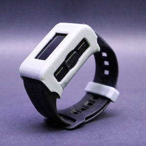 May include: A white and black wristwatch with a digital display and a black rubber band.