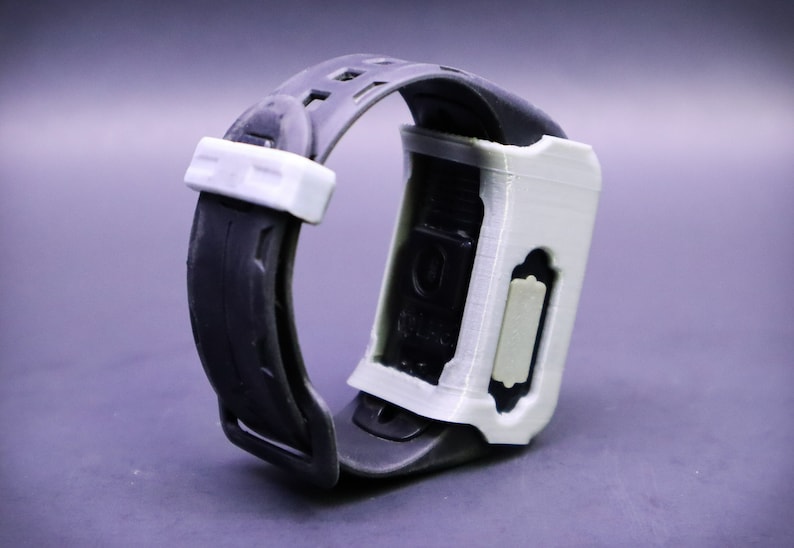May include: A white and black wristwatch with a black strap and a white case. The watch has a rectangular face and a white button on the side.