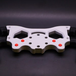 May include: White plastic steering wheel frame with black grips and red buttons.