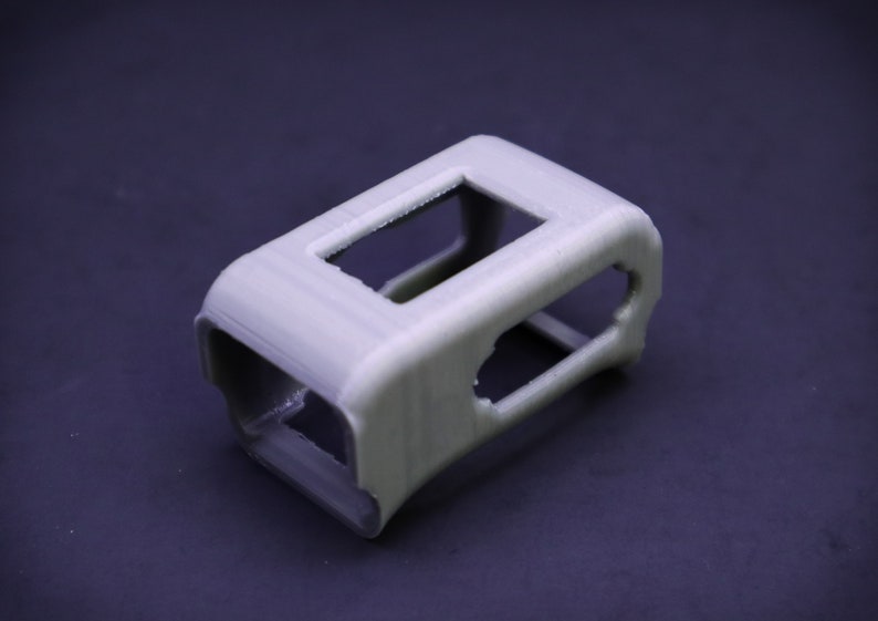 May include: A gray 3D printed case with multiple openings. The case is designed to hold a small electronic device.