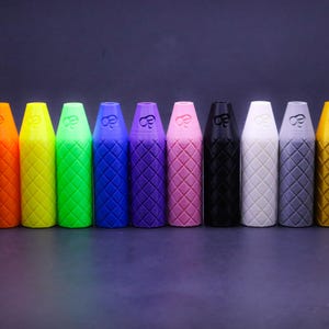 May include: A row of 12 colorful, textured, cylindrical containers with a diamond pattern. The containers are arranged in a rainbow color order from red to gold.