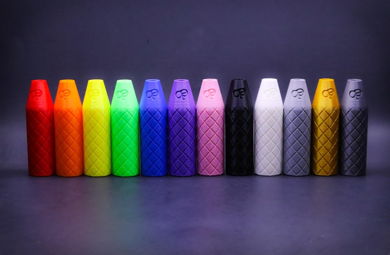 May include: A row of 12 colorful, textured, cylindrical containers with a diamond pattern. The containers are arranged in a rainbow color order from red to gold.
