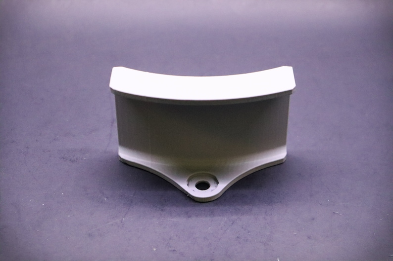 May include: White plastic curved bracket with a hole in the bottom.