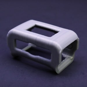 May include: A gray plastic 3D printed case with a rectangular opening.