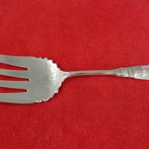 May include: A silver serving fork with an ornate design and the text "1847 Rogers Bros." on the handle.
