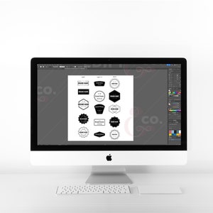 Black and white badge logos on an imac desktop using adobe illustrator.