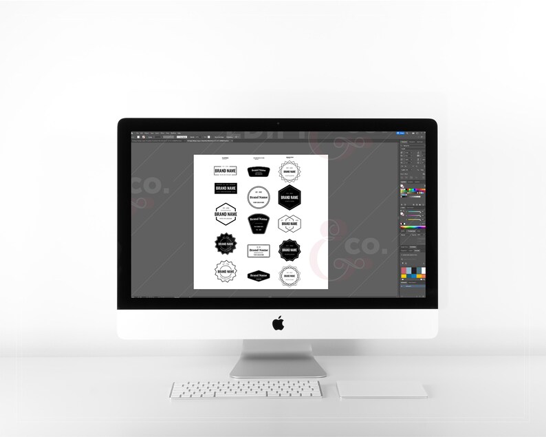 Black and white badge logos on an imac desktop using adobe illustrator.