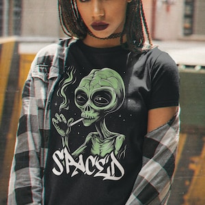May include: A black t-shirt with a green alien smoking a cigarette and the word "SPACED" written in graffiti style.