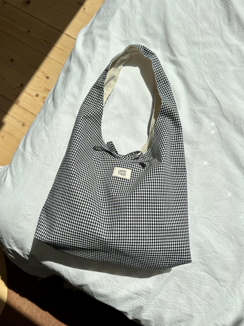 May include: A black and white gingham tote bag with a white label that says "Pony Boys".