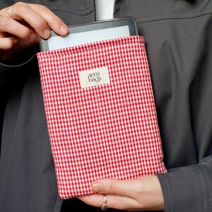 May include: Red and white gingham fabric tablet case with the text "aeny bags" on a white label.