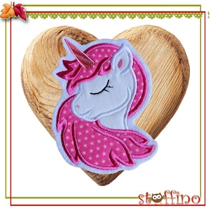 Könnte beinhalten: Ein rosa-weißes Einhorn-Applikationsmotiv mit rosa Mähne und Schweif mit weißen Sternen. Das Einhorn hat die Augen geschlossen und ein rosa Horn.