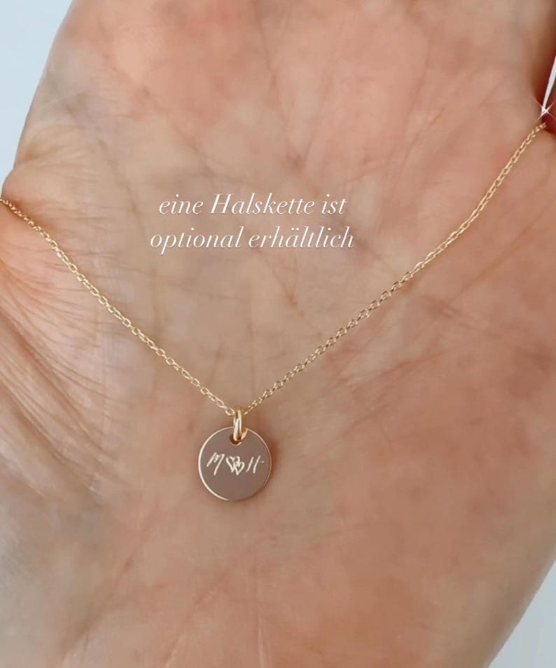 May include: A gold necklace with a small round pendant engraved with the word "MOM" and a heart. The text "eine Halskette ist optional erh&auml;ltlich" is visible in the image.
