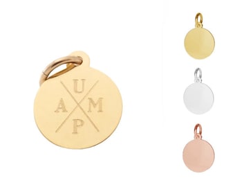 May include: Gold, silver, and rose gold round disc charm with a ring for attaching to a necklace or bracelet. The gold charm has the letters UAMP inscribed on it in a cross pattern.