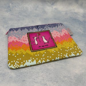 Könnte beinhalten: Eine rosa und gelbe Reißverschlusstasche mit einem Pixelmuster. Die Tasche zeigt eine gerahmte Illustration von zwei Mäusen, eine hält eine Blume, mit dem Text "For my lovely".