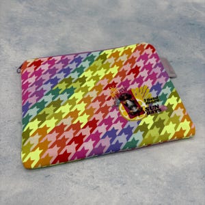 Könnte beinhalten: Eine rechteckige Reißverschlusstasche mit einem Regenbogen-Hahnentrittmuster. Die Tasche hat eine kleine Grafik mit dem Text "I need more SUN DAYS". Die Farben sind Rot, Orange, Gelb, Grün, Blau und Lila.